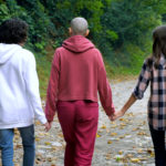 Bald,Woman,,Mother,And,Her,Teenage,Children,Walk,Together,In