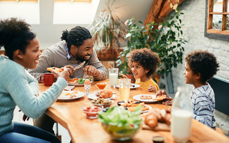 Happy,Black,Parents,And,Their,Kids,Talking,While,Having,Breakfast