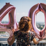 Attractive,Curly,Brunette,Celebrating,Her,40th,Birthday,With,Big,Balloons